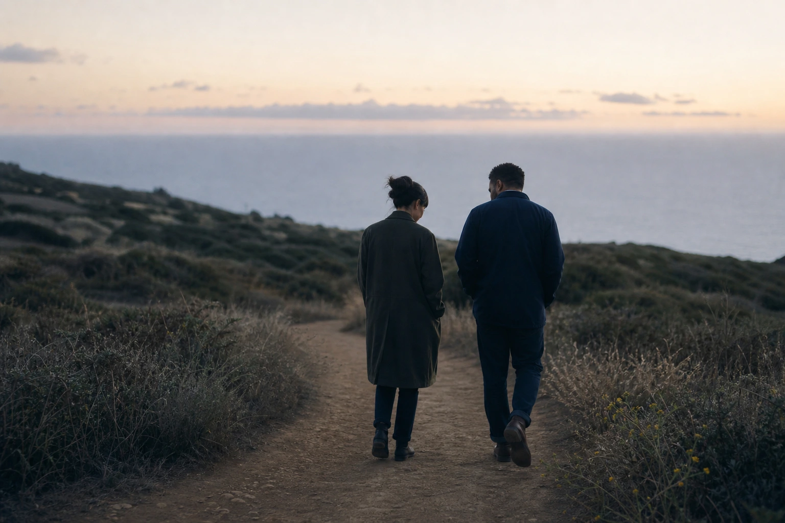 Two people walking together through a quiet landscape